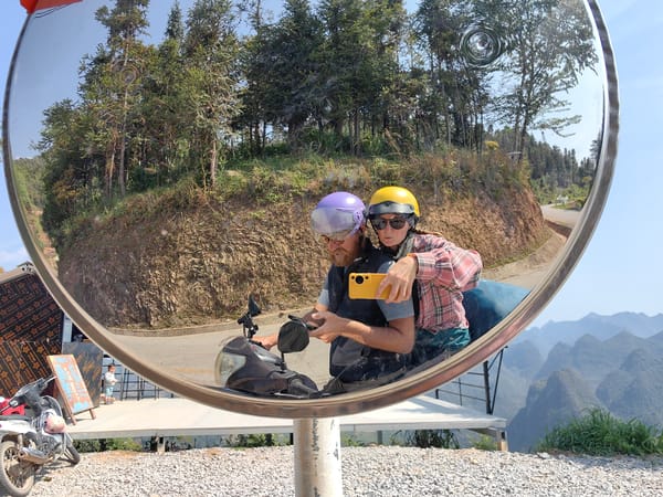 Couple takes mirror selfie on scooter in Vietnam