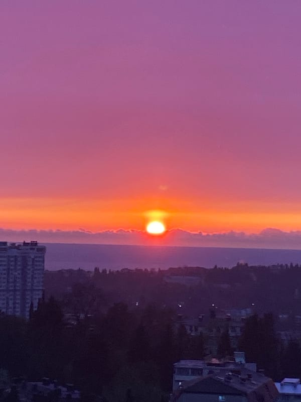 Vibrant sunset paints Sochi skyline in orange and pink hues
