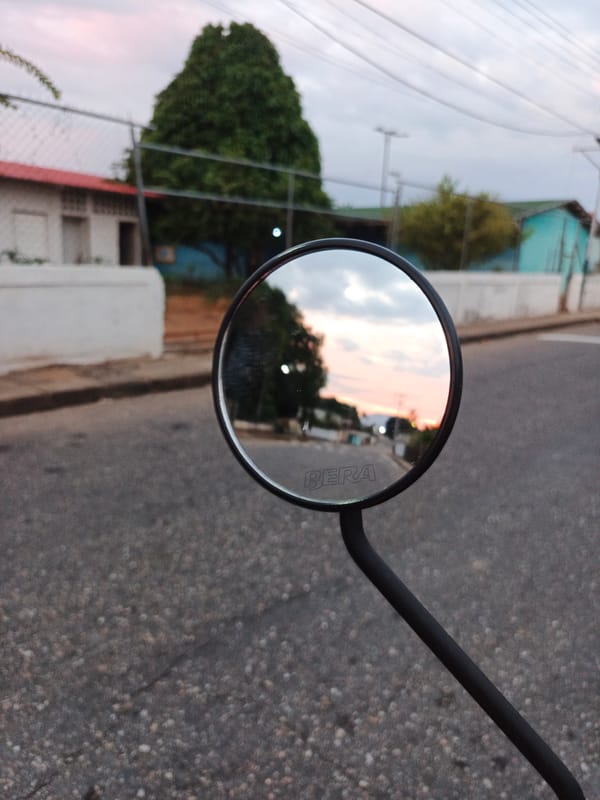 Motorcycle mirror captures street view in Tinaco, Venezuela