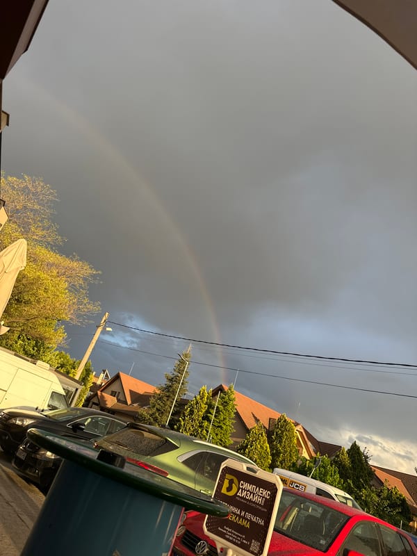 Rainbow appears over Plovdiv streets on overcast afternoon