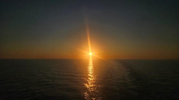 Sun hits the horizon over Swedish coastal waters at dusk.