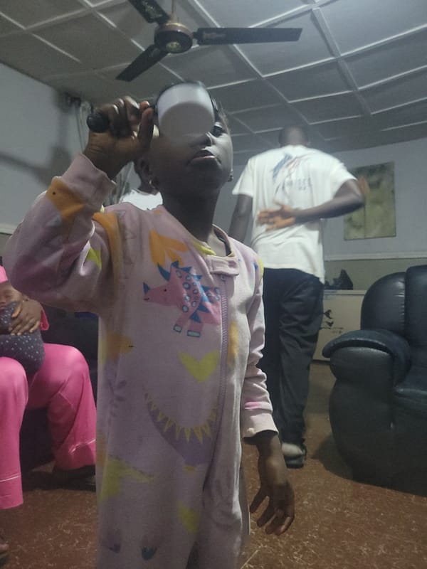 Child in unicorn pajamas holds white object indoors