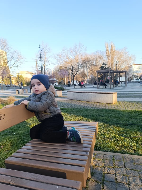 Child sits on park bench in Simferopol on sunny day