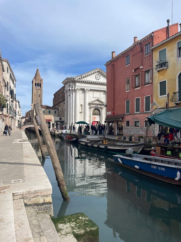 Tourists capture classic Venice canal scenes during midday sightseeing