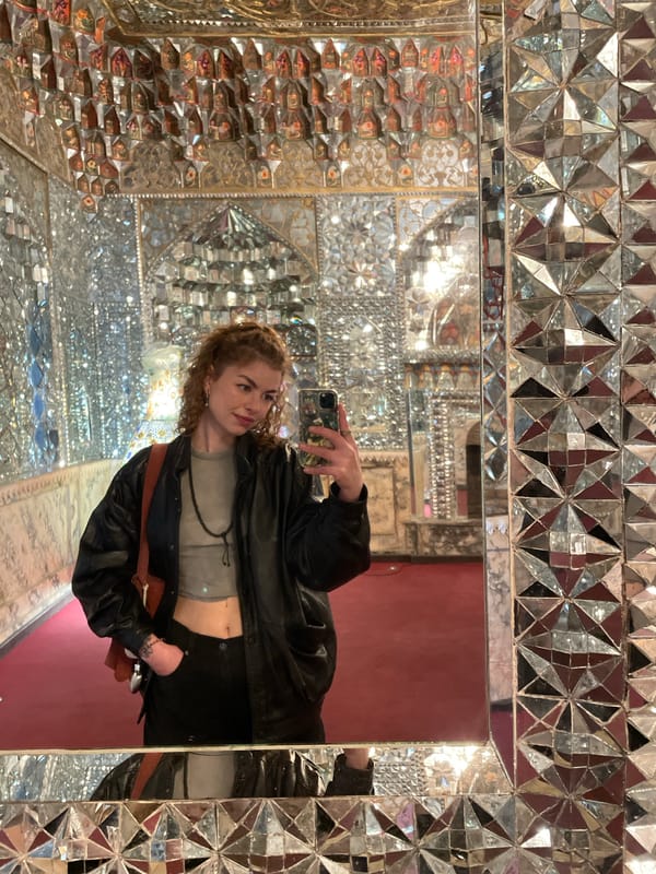 Woman takes mirror selfie in ornate kaleidoscopic room, Tbilisi