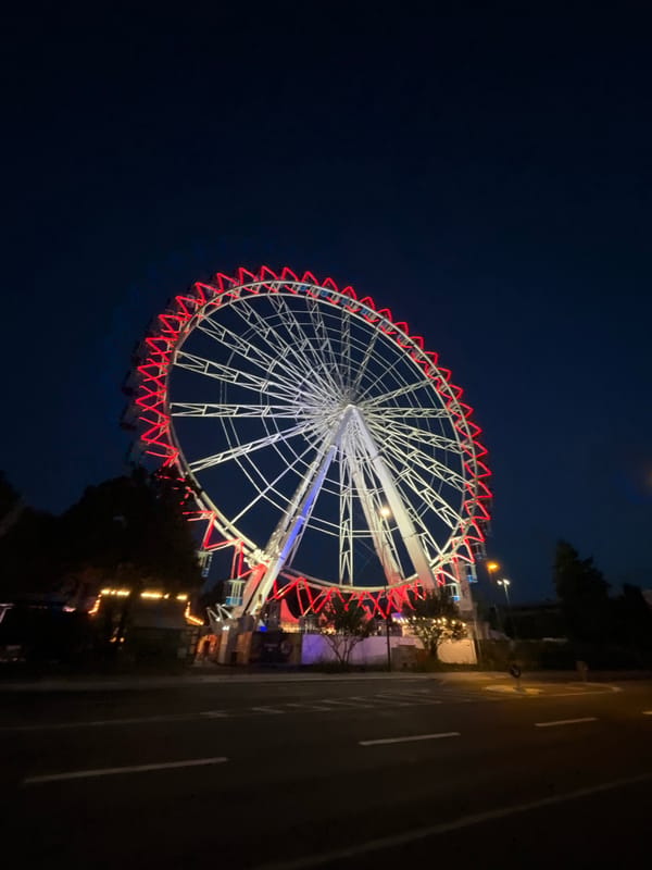 Ferris wheel and medieval minster light up a Neuss evening