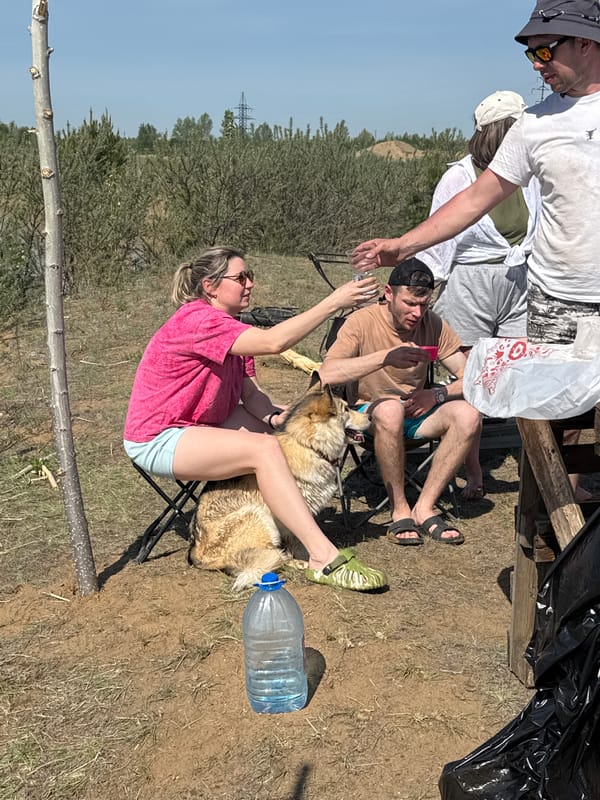 Group relaxes outdoors with dog in Noviy, Russia