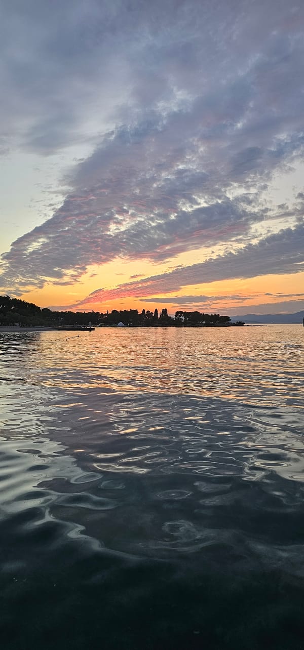 Supetar waterfront at golden hour: ferries, painters, and promenade life