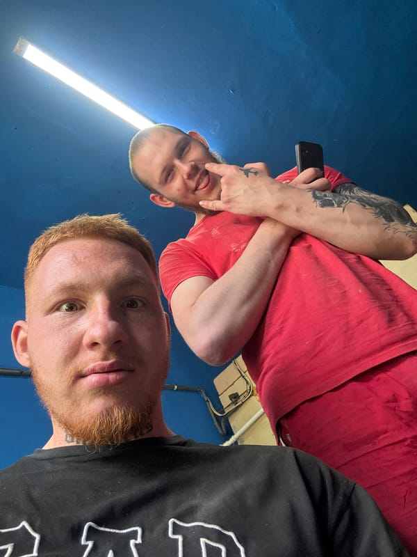Two men take selfies indoors in Makiivka, Ukraine