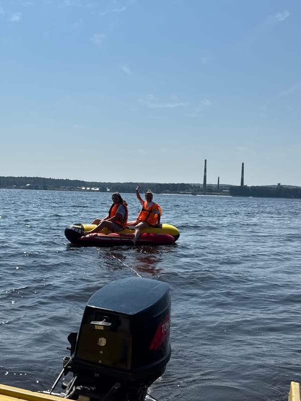 Banana boat and motorboat out on a Russian river