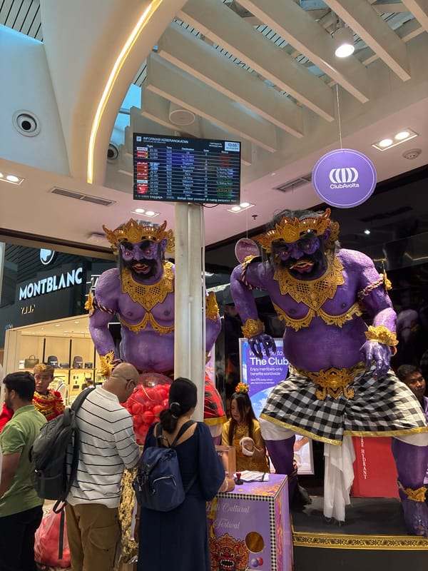 Kuta airport terminal observed with Balinese statues, duty-free shops