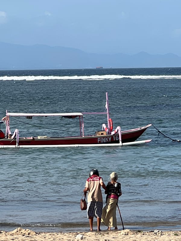 Sanur Beach promenade buzzing with cyclists, beachgoers, and street life