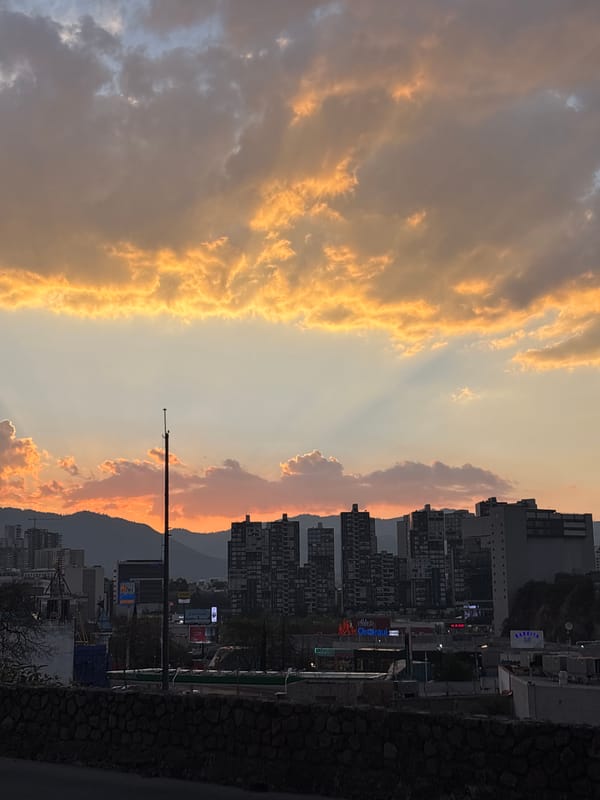 Sunset illuminates urban Huixquilucan skyline against mountain backdrop