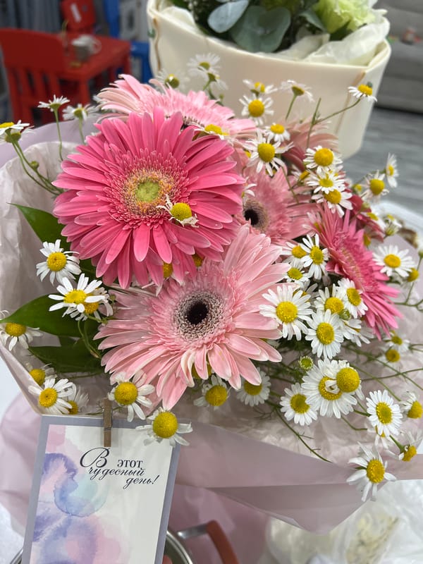 Pink and white flower bouquet with Russian celebration card