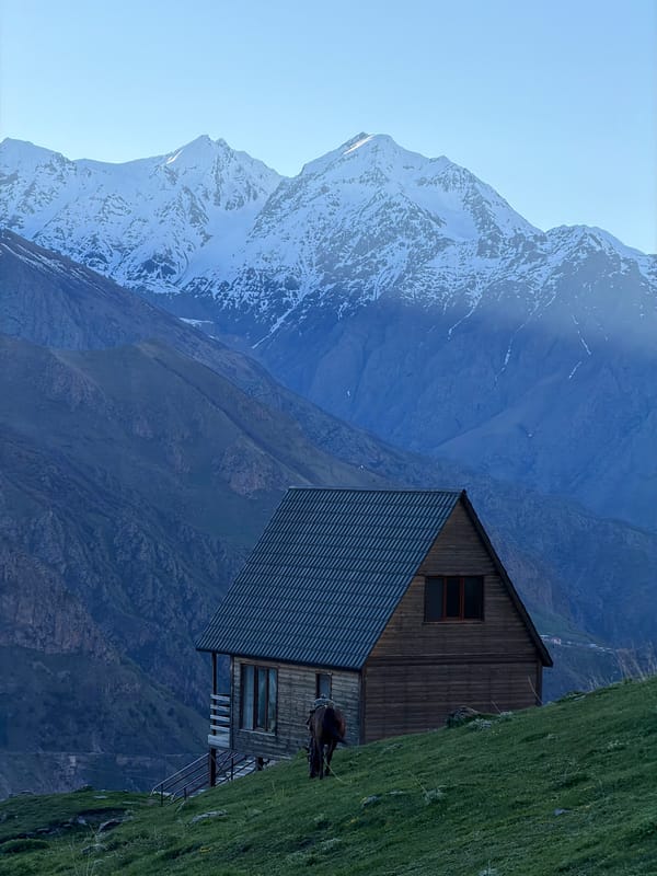 Person, horse spotted near mountain building in Stepantsminda, Georgia