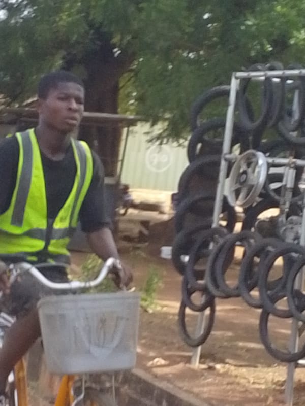 Young cyclist rides dusty streets in Tamale, Ghana