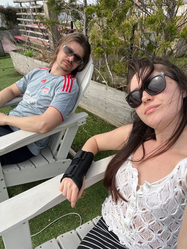 Two people rest together on wooden bench in New York