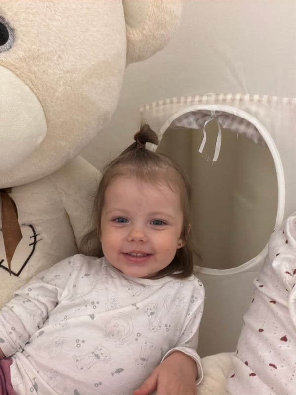Toddler plays with teddy bear in Reshetnikovo home