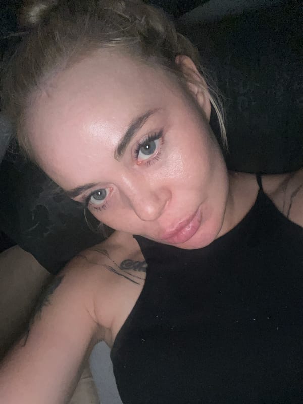 Close-up selfie session, lying down, dim indoor setting