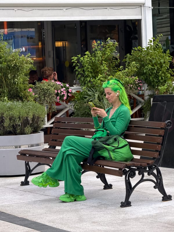 Full green fit on a Moscow park bench, phone in hand