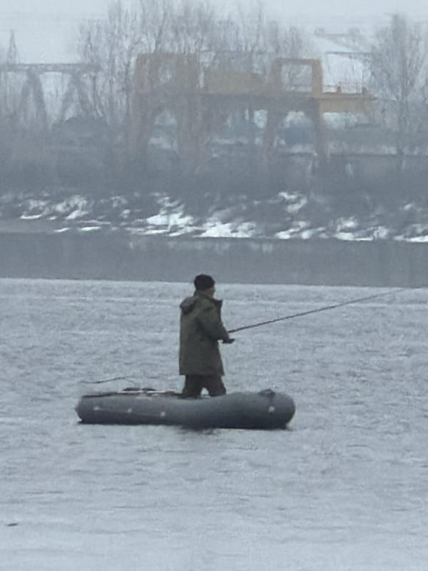 Ice fisherman catches small fish in Chaikovsky, Russia