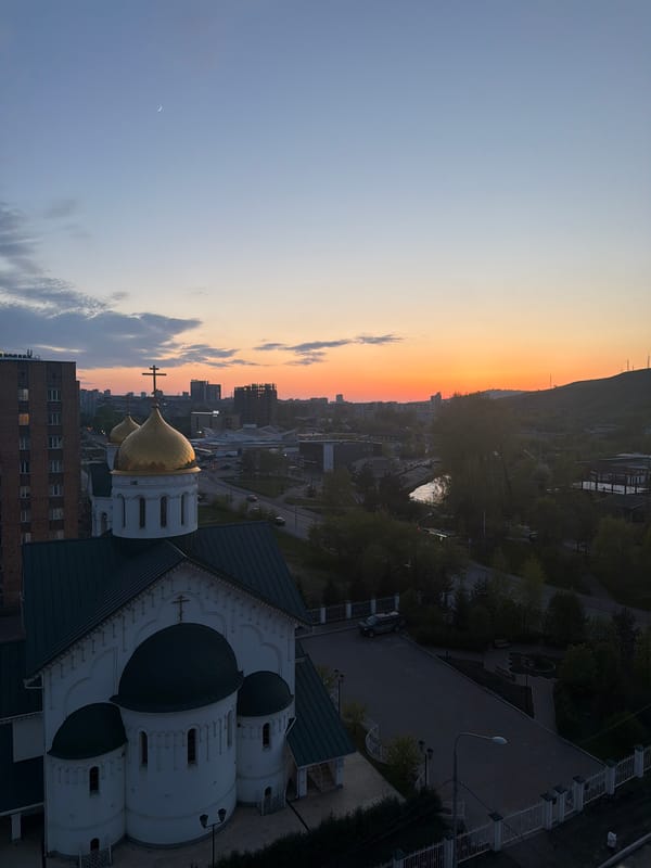 Crescent moon visible during city sunset observation