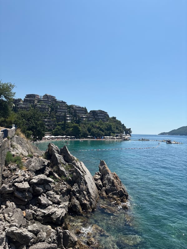 Budva's rocky coastline and resort hillsides on a clear summer morning