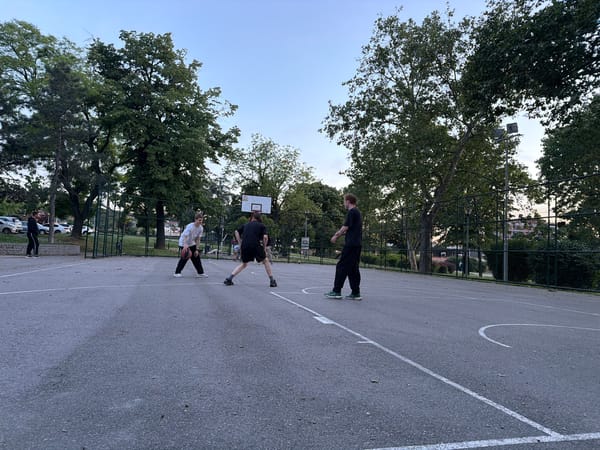 Pickup basketball game observed on Belgrade court at sunset