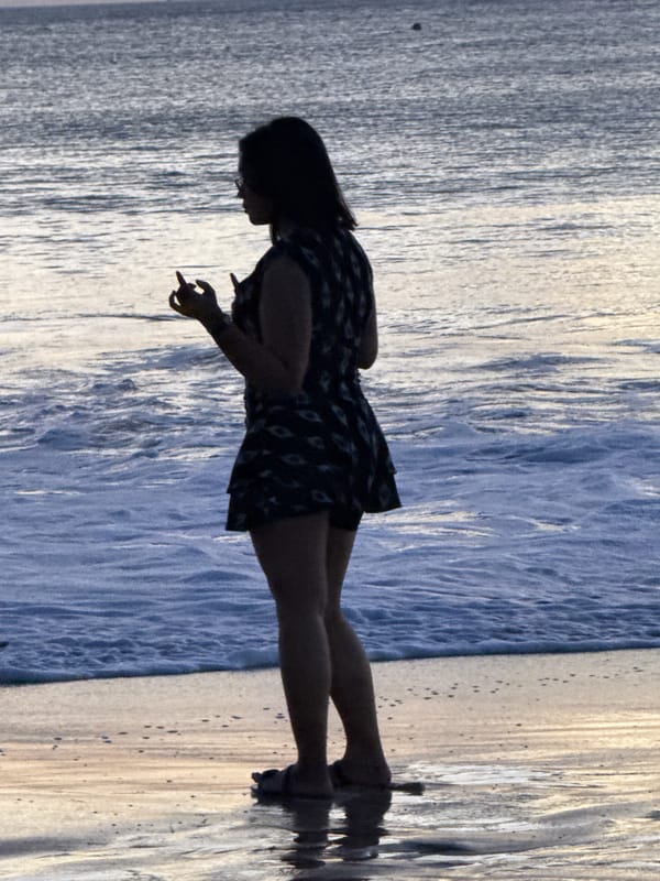 Kuta Beach shoreline activity during golden-hour overcast light