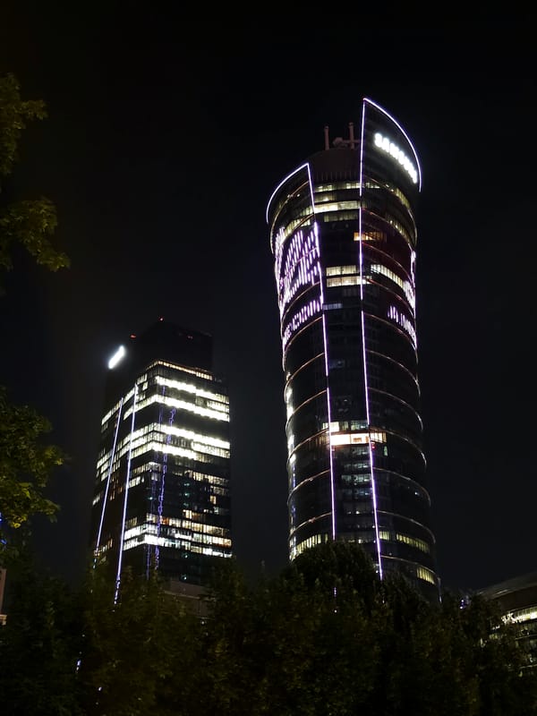 Warsaw's Rondo Daszyńskiego district glowing on a rainy night
