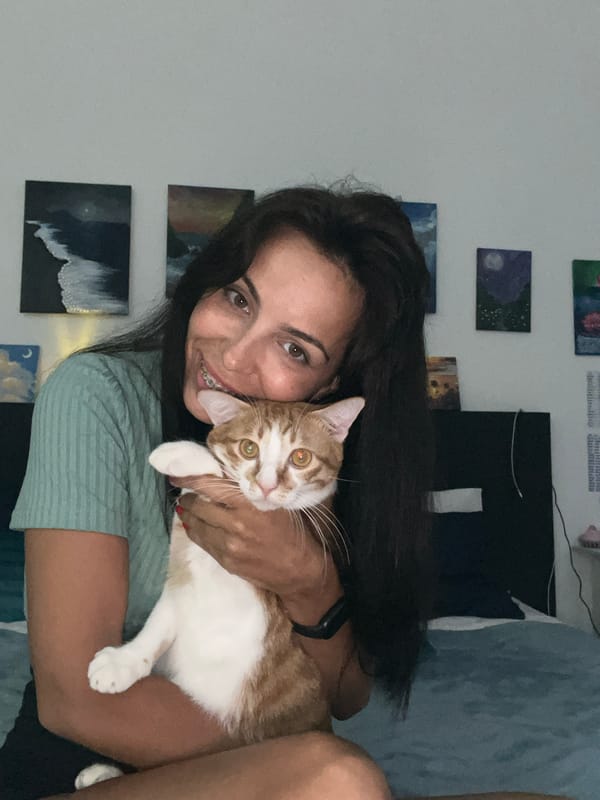 Woman takes selfies with orange cat in Indonesian home