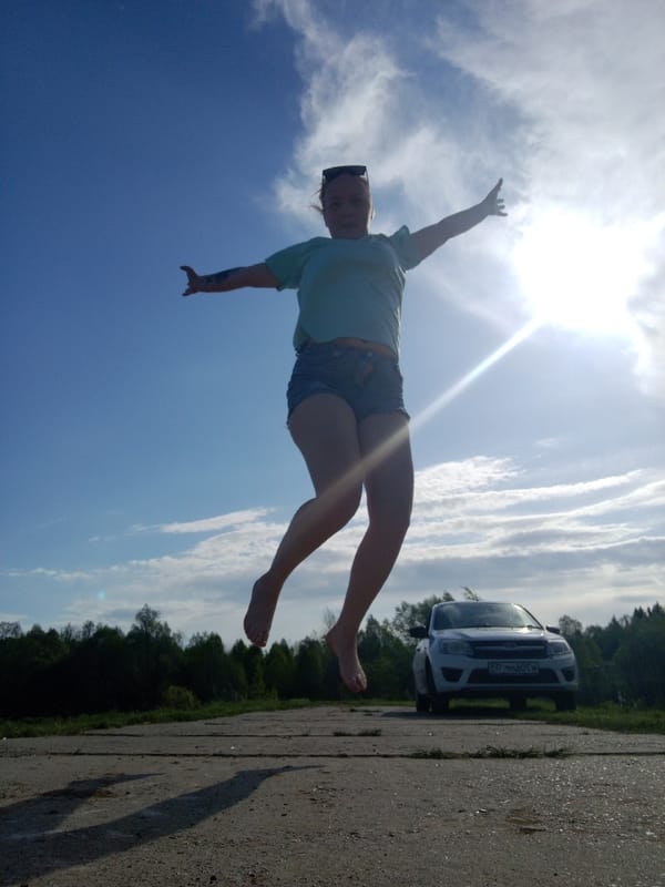 Woman performs outdoor poses near waterway in Уральское, Russia