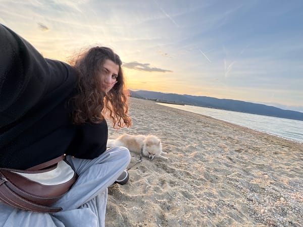 Woman takes sunset beach selfies with Pomeranian in Greece