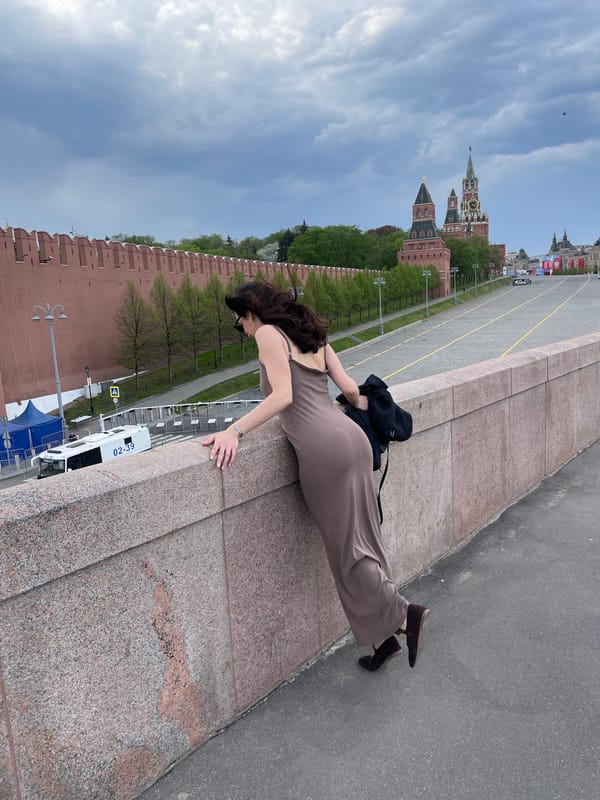 Woman leans over stone wall near Kremlin in Moscow