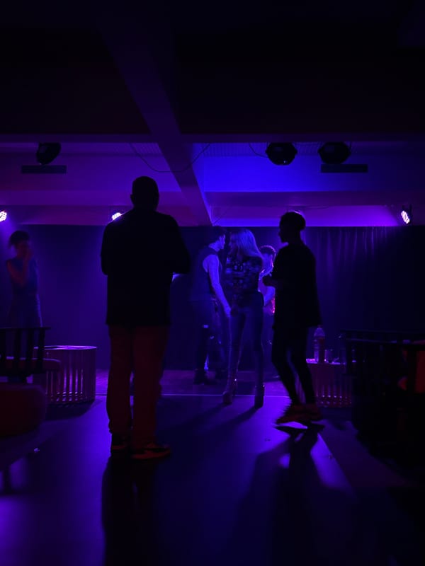 Late-night Buenos Aires event with dramatic stage lighting and a standout white gown