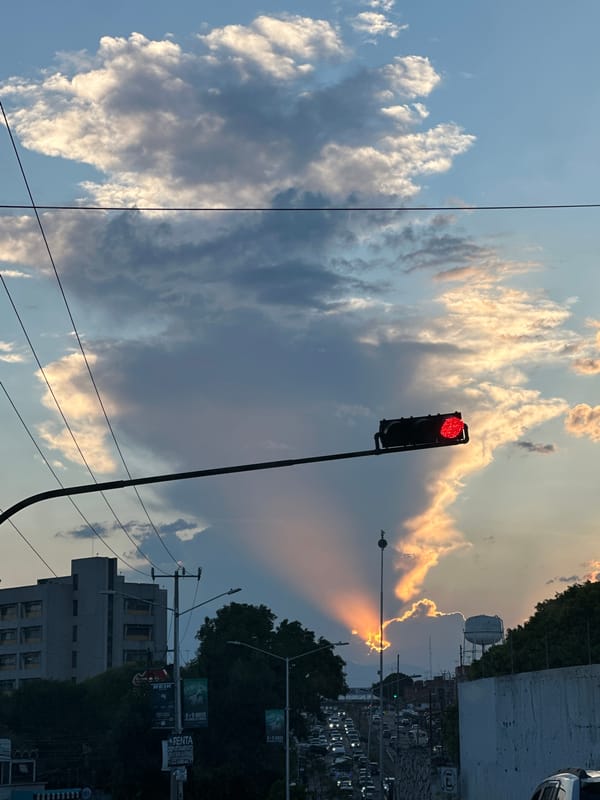 Red traffic light observed under cloudy skies in Puebla