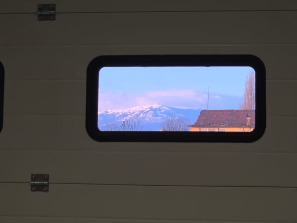 Window view captures snow-capped mountain landscape scene