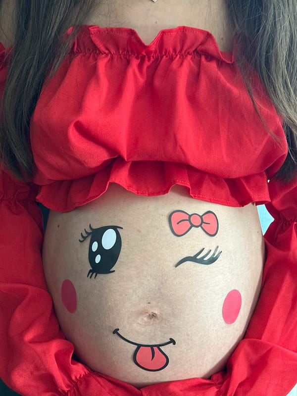 Pregnant woman celebrates with belly art and chocolate in Wisła