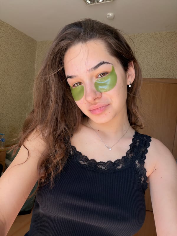 Woman applies green skincare patches during beauty routine in Sofia