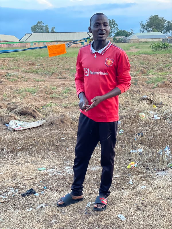 Posing in a Man United jersey across rural Nigerian fields