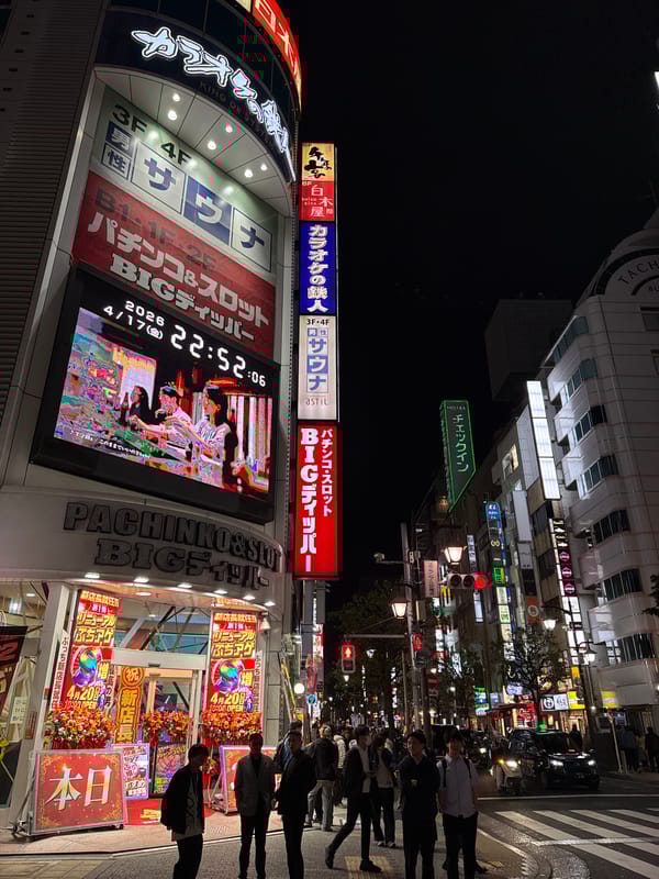 Evening street life continues in Minato's neon-lit districts