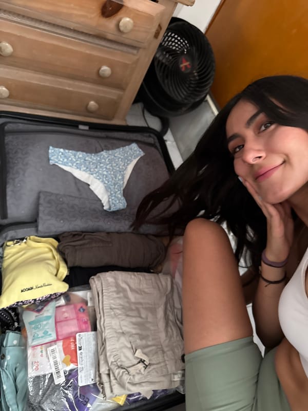 Woman packs travel suitcase with clothing in Puebla