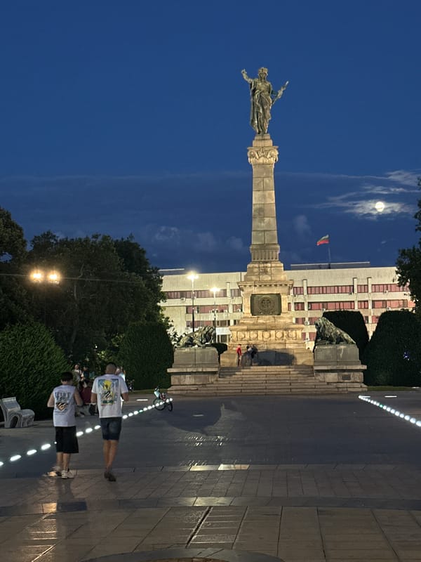 Monument and street life in central Ruse at dusk