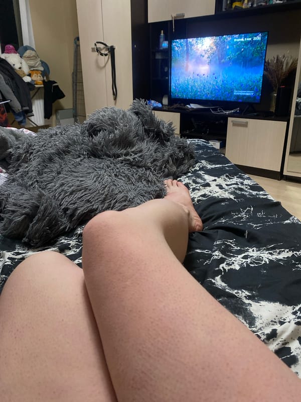 Person relaxes with beer and snacks on bed in Yekaterinburg