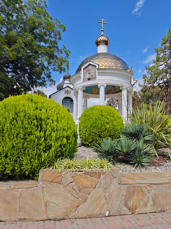Military memorial park with sculptures, a tank, and a domed gazebo