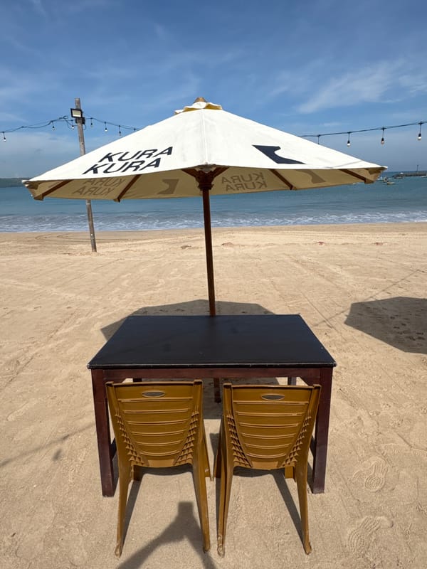 Tourist captures Kuta beach dining, decorated Ganesha statue, floral arch