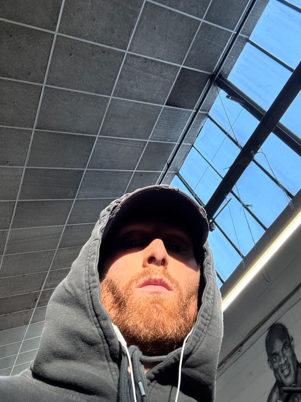 Person in hoodie photographed looking up indoors in London