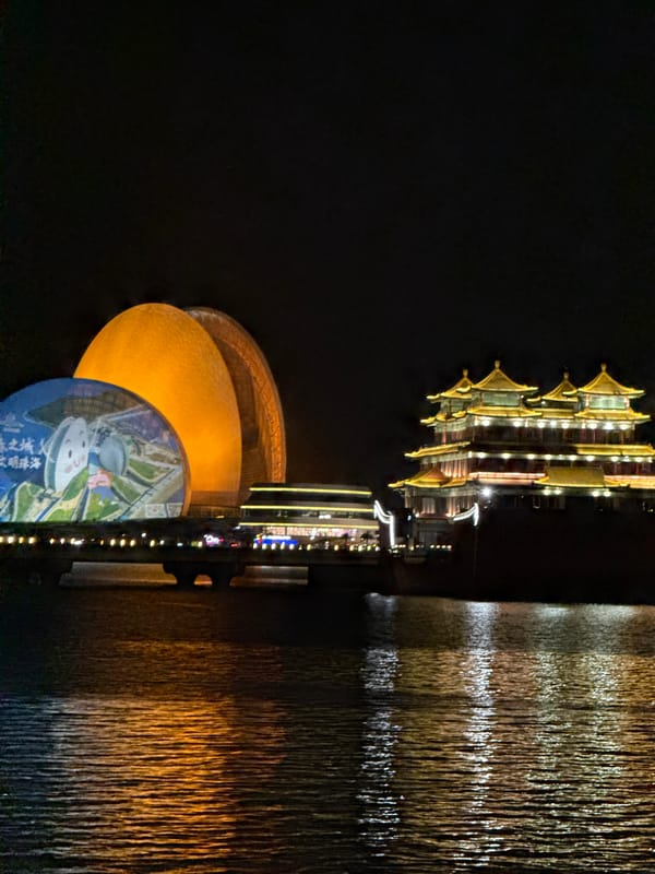Evening Tai Chi and illuminated architecture at Xiangzhou waterfront