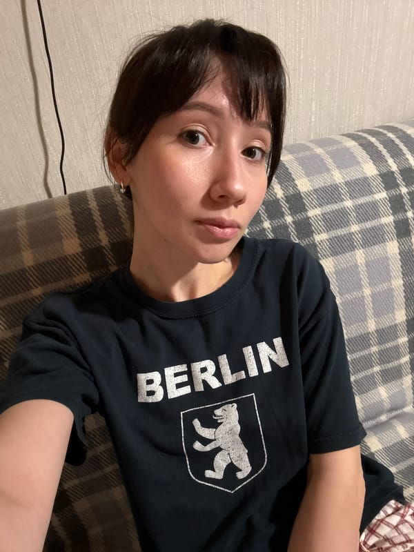 Woman in Berlin t-shirt resting on plaid surface in Kazan