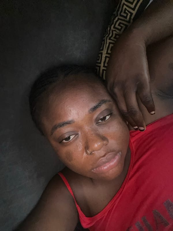 Young woman uses smartphone in bed, Abuja morning